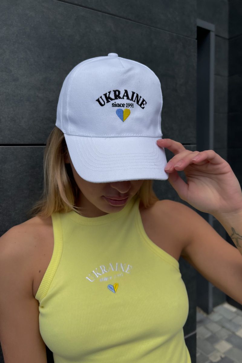 Кепка белого цвета с вышивкой UKRAINE и сердцем 1 Кепка белого цвета с вышивкой UKRAINE и сердцем 1