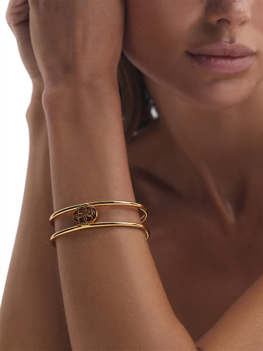 Браслет кафф золотого кольору з бренд елементом 1