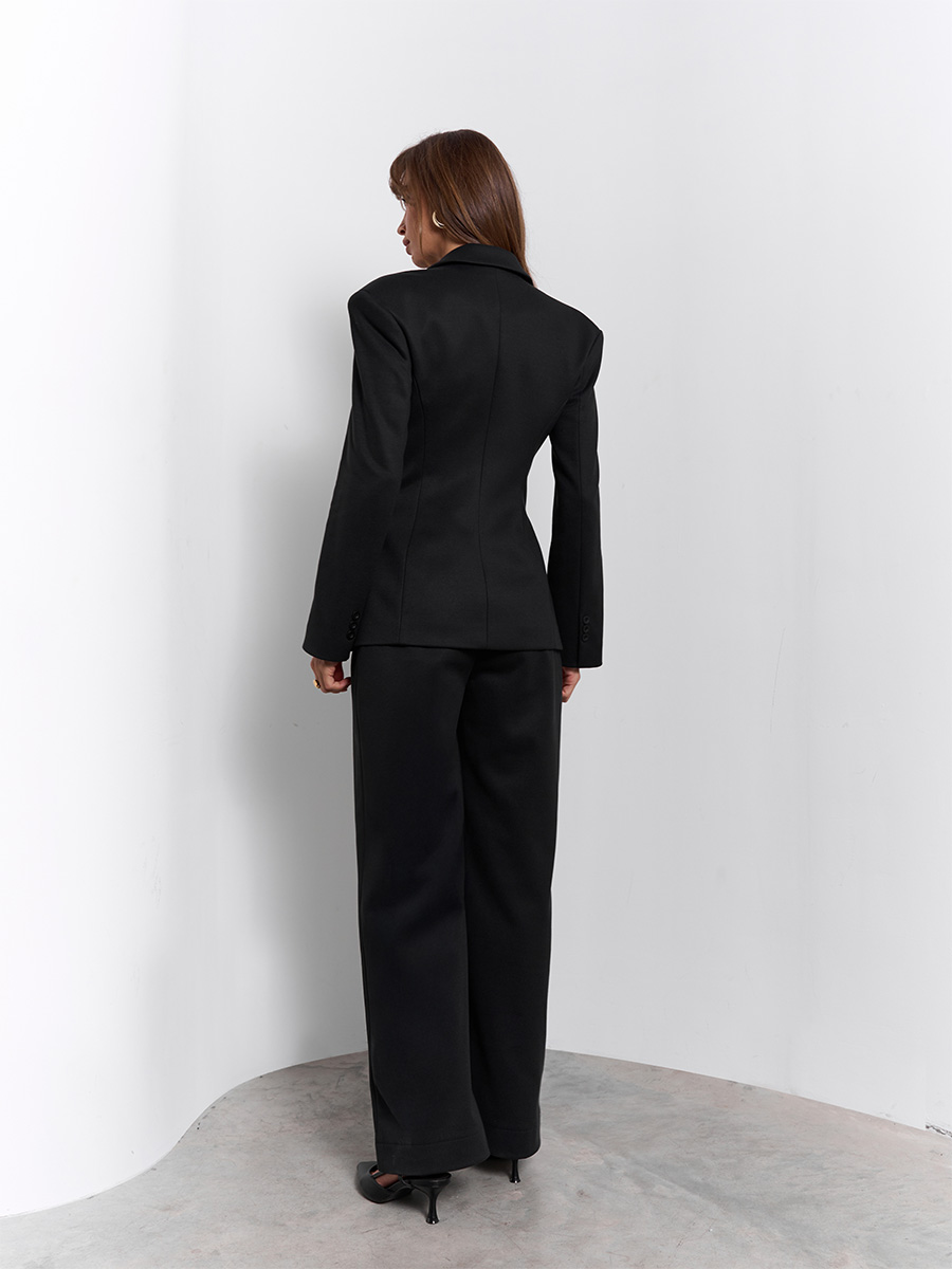 Костюм чорного кольору з жакетом з декоративними кишенями та штанами зі скісними шльовками 1