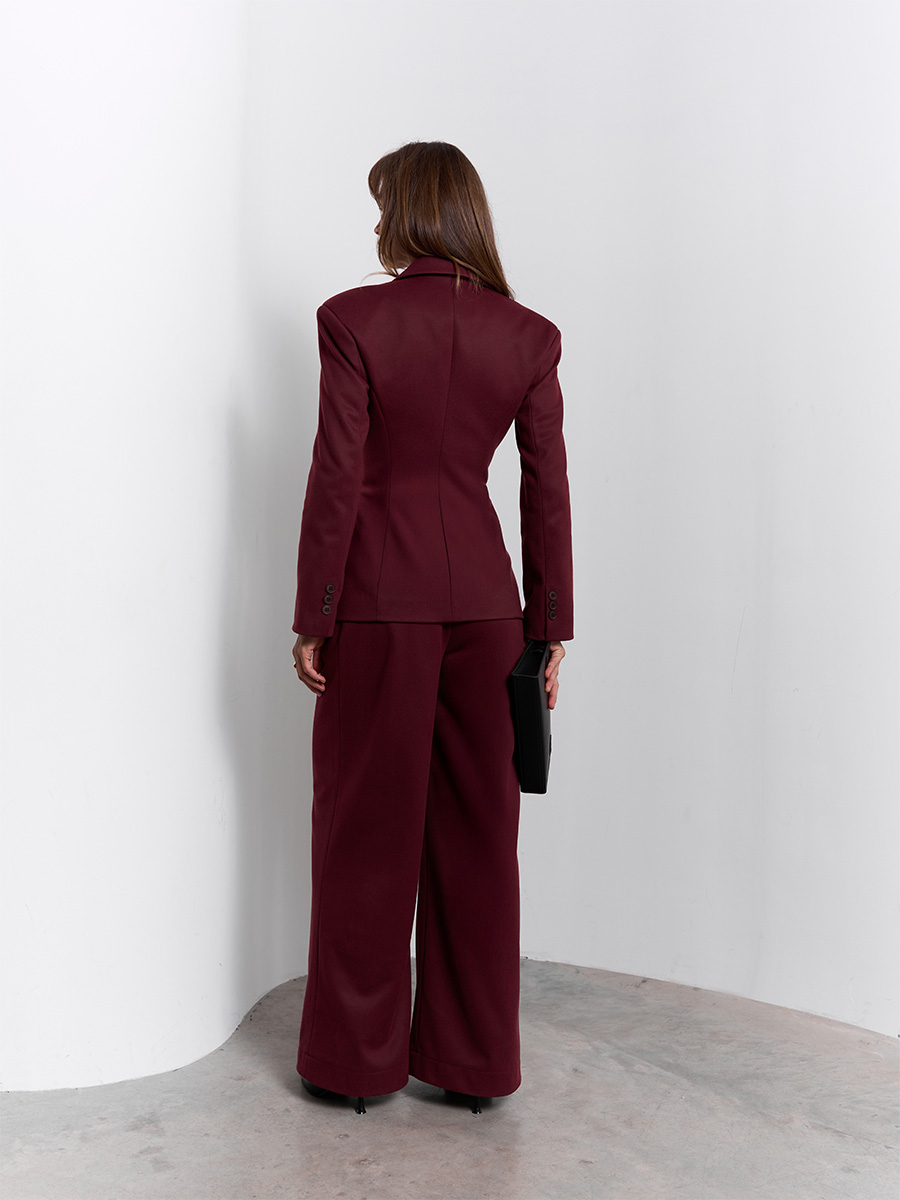 Костюм бордового кольору з жакетом з декоративними кишенями та штанами 1